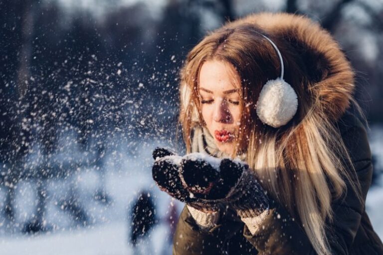 Winter People - woman blowing snow on her hands