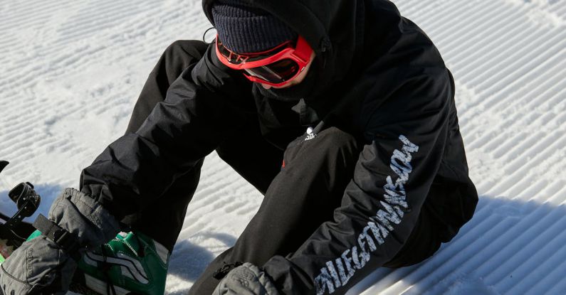Winter Sport - A Man Putting on a Snowboard