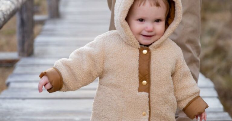 Winter Family Fun - Child in Brown Jacket and Brown Pants Walking on Wooden Bridge